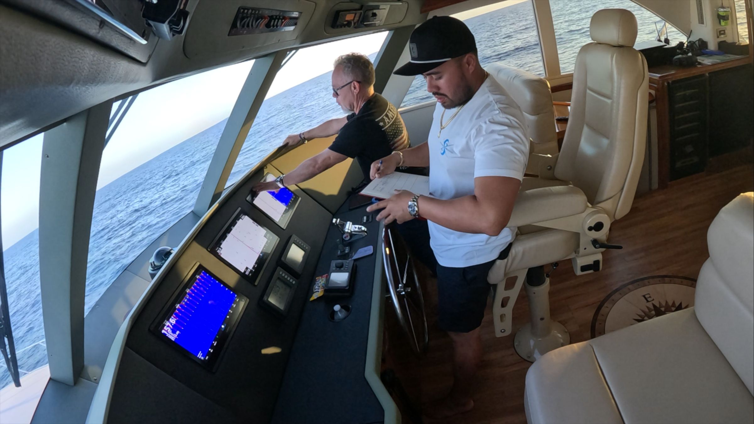 Captain Luis Sotero at the helm of a 68' Viking, writing in the log